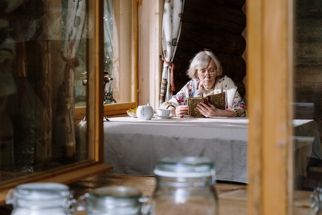 older woman reading at table