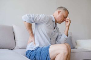 Man suffering from back pain at home