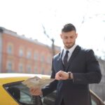 Man In Black Suit Standing Beside The Yellow Car