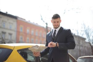 Man In Black Suit Standing Beside The Yellow Car
