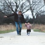 A Father and his Little Girl Running on a Park Pathway