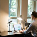 man-in-white-dress-shirt-sitting-on-chair-using-laptop-computer