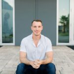 a-man-sitting-on-the-ground-in-front-of-a-building