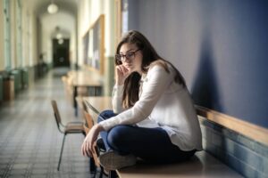 woman-in-white-long-sleeve-shirt-and-blue-denim-jeans-sitting-on-table